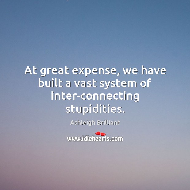 At great expense, we have built a vast system of inter-connecting stupidities. Ashleigh Brilliant Picture Quote