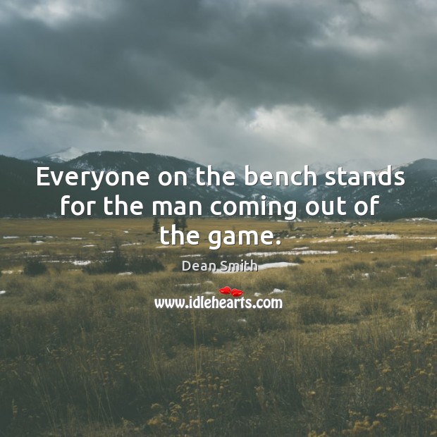 Everyone on the bench stands for the man coming out of the game. Image