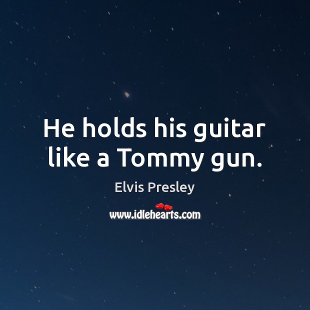 He holds his guitar like a Tommy gun. Image