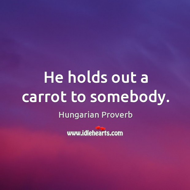 He holds out a carrot to somebody. Image