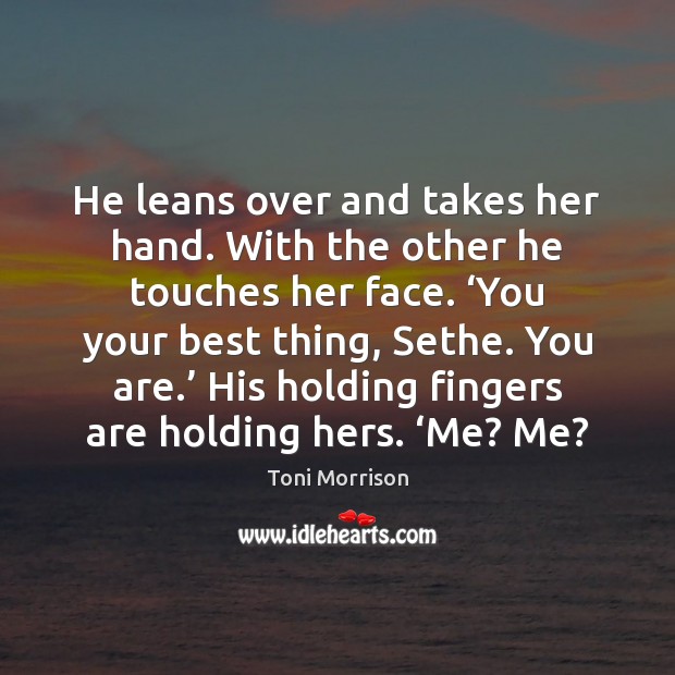 He leans over and takes her hand. With the other he touches Image