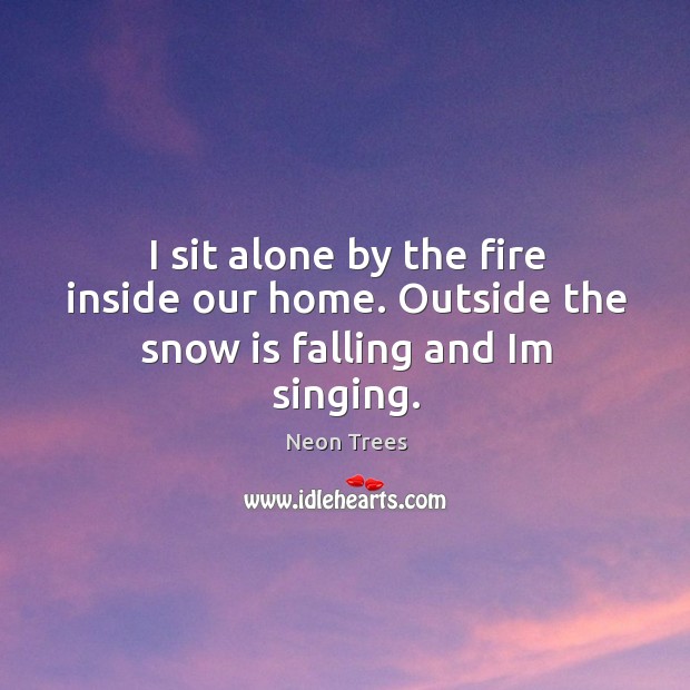 I sit alone by the fire inside our home. Outside the snow is falling and im singing. Image