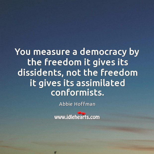 You measure a democracy by the freedom it gives its dissidents, not the freedom it Abbie Hoffman Picture Quote